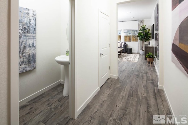 hall with baseboards and dark wood-style flooring