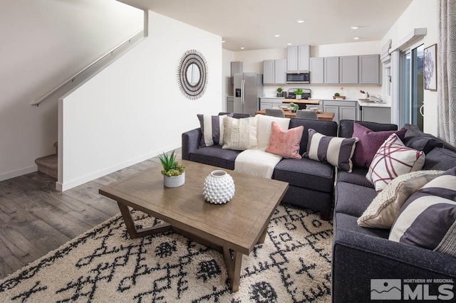 living room with light wood-type flooring, stairway, baseboards, and recessed lighting