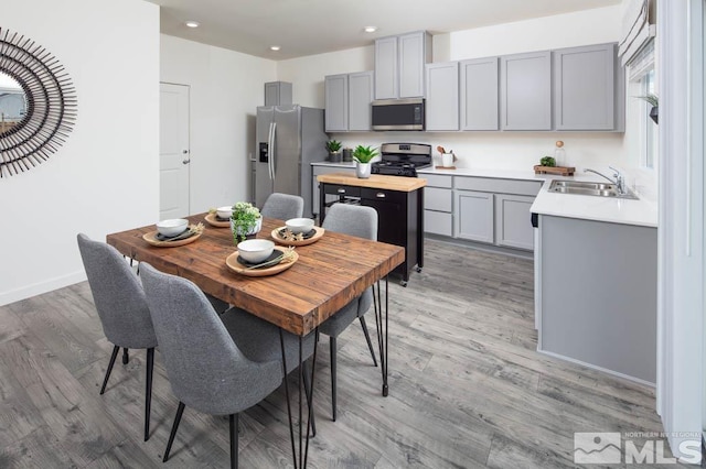 dining space with recessed lighting, baseboards, and light wood finished floors