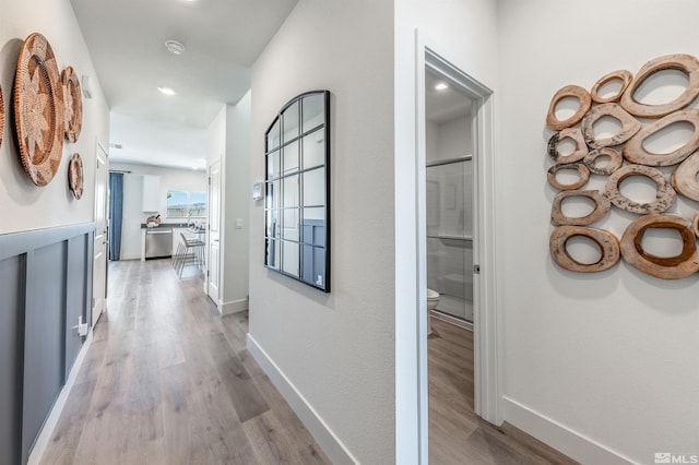 hall featuring baseboards and light wood-style floors