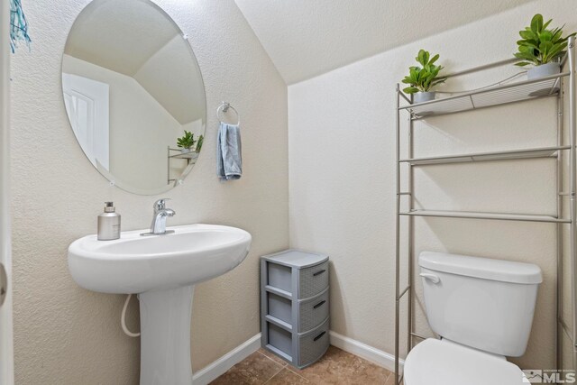 half bath featuring toilet and baseboards