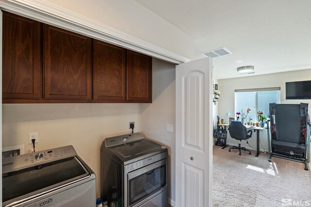 laundry area featuring light colored carpet, cabinet space, visible vents, and washer and clothes dryer