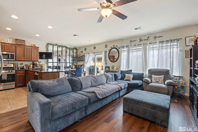 living area featuring wood finished floors, visible vents, and ceiling fan