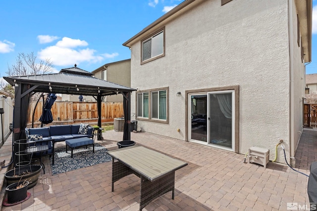 view of patio / terrace with a gazebo, an outdoor hangout area, central AC, and a fenced backyard
