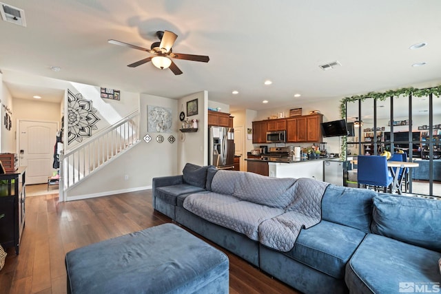 living room with visible vents, stairway, and dark wood-style flooring