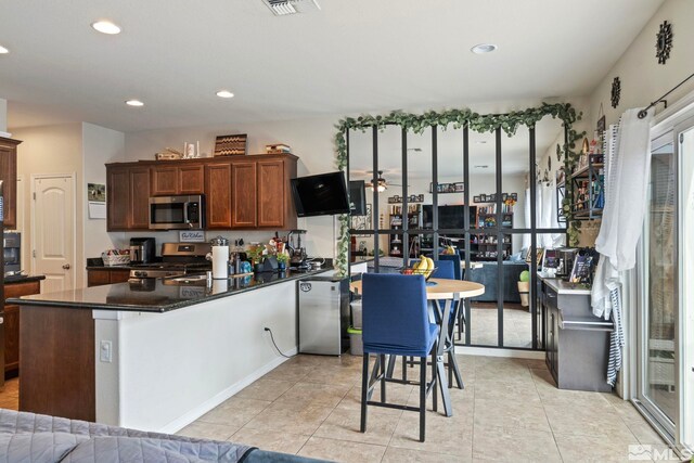 kitchen with dark countertops, light tile patterned floors, recessed lighting, and appliances with stainless steel finishes