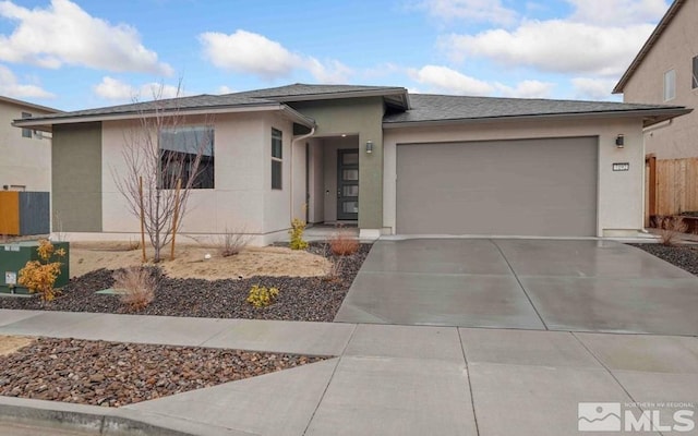 view of front of home featuring concrete driveway, an attached garage, fence, and stucco siding