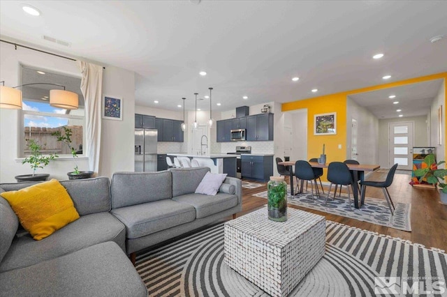 living room with dark wood finished floors, recessed lighting, and visible vents