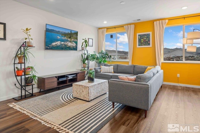 living area with recessed lighting, wood finished floors, and baseboards