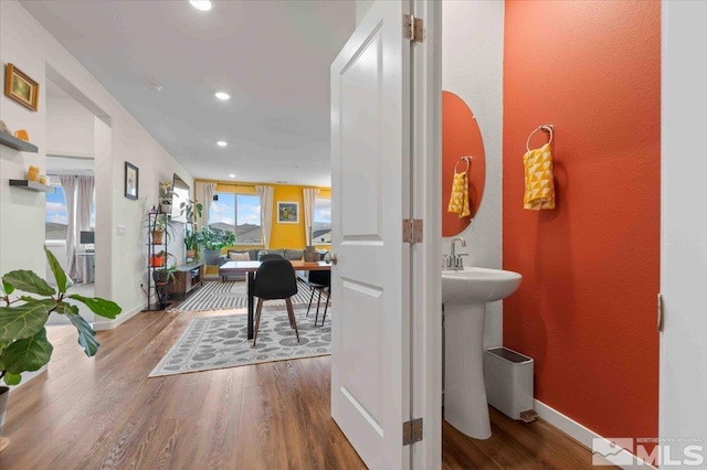 hall featuring recessed lighting, baseboards, and wood finished floors