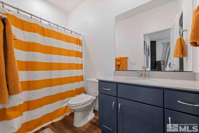 full bathroom with a shower with curtain, toilet, wood finished floors, and vanity