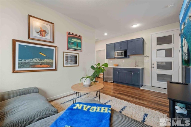 living area featuring recessed lighting, wood finished floors, and baseboards