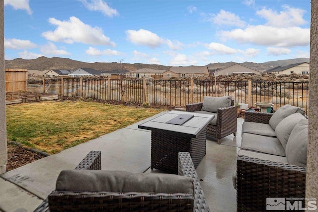 view of patio / terrace with an outdoor living space, a mountain view, and a fenced backyard