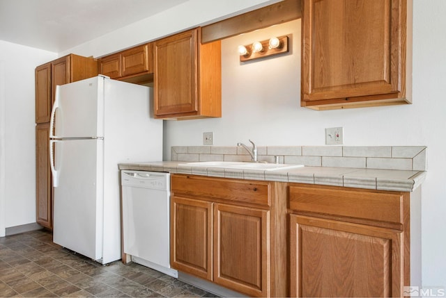 kitchen with a sink, dishwasher, brown cabinetry, and stone finish floor