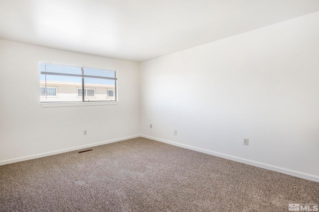 unfurnished room featuring visible vents, carpet, and baseboards