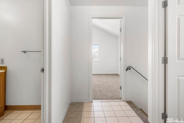 bathroom with tile patterned floors, baseboards, vanity, and vaulted ceiling