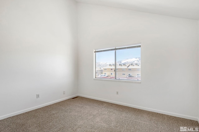 empty room featuring baseboards and carpet flooring