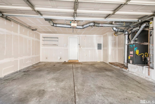 garage featuring electric panel, heating unit, and a garage door opener