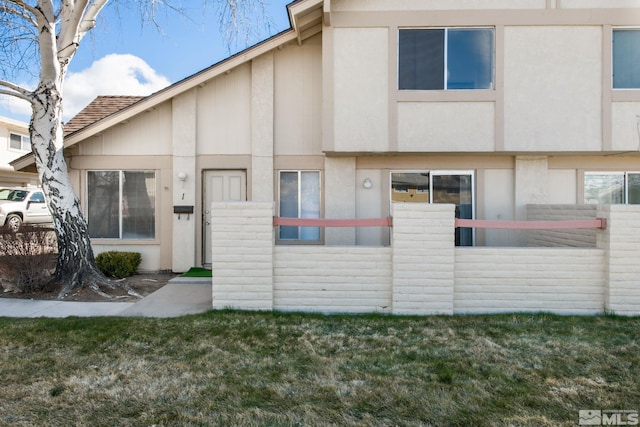 view of front of home with stucco siding and a front lawn