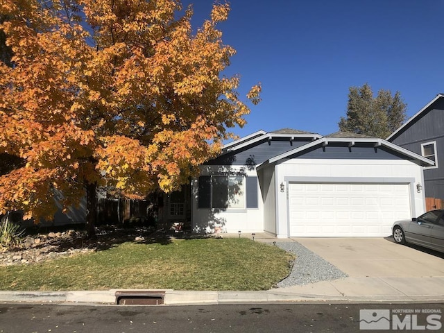 view of front of house featuring a front lawn, concrete driveway, and a garage