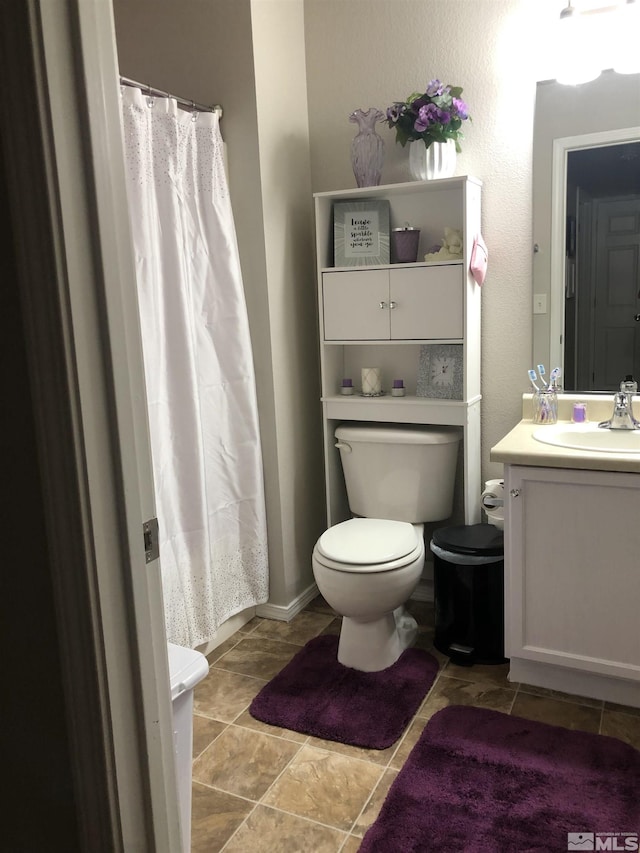 full bathroom featuring toilet, vanity, and a shower with curtain