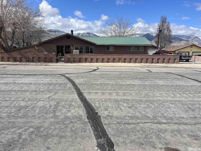 view of front of home featuring metal roof and fence