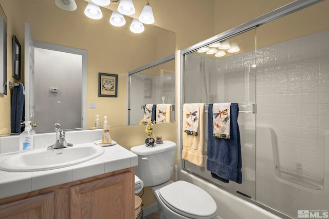 full bath with bath / shower combo with glass door, toilet, and vanity