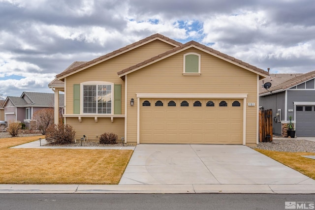 view of front of house featuring a garage, a tiled roof, concrete driveway, and a front yard