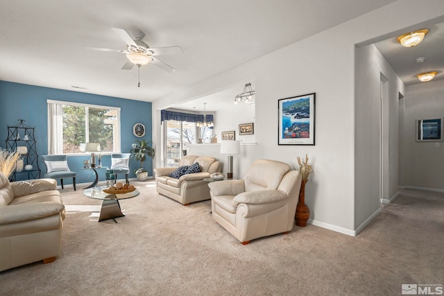 living room with visible vents, carpet, baseboards, and ceiling fan