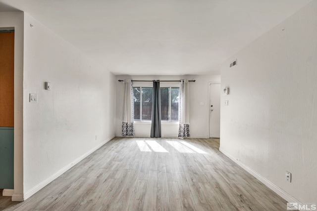 spare room featuring visible vents, wood finished floors, and baseboards