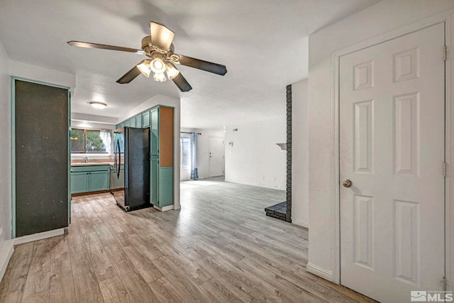 kitchen featuring freestanding refrigerator, light wood finished floors, green cabinets, and ceiling fan