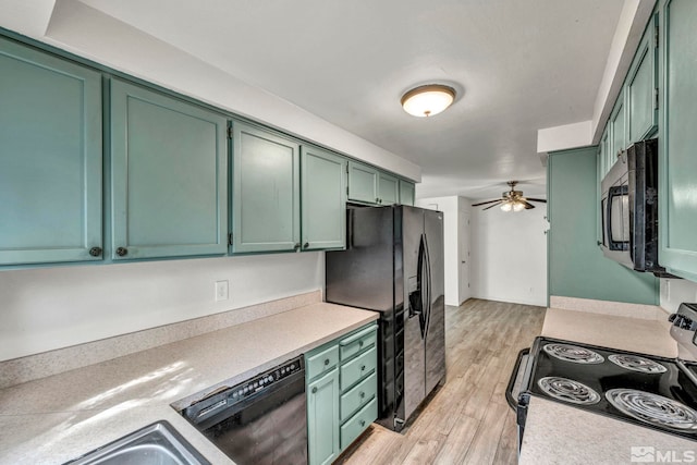 kitchen with light wood-type flooring, black appliances, green cabinets, and ceiling fan