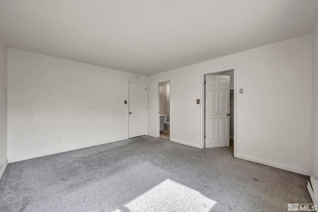 carpeted spare room featuring baseboards