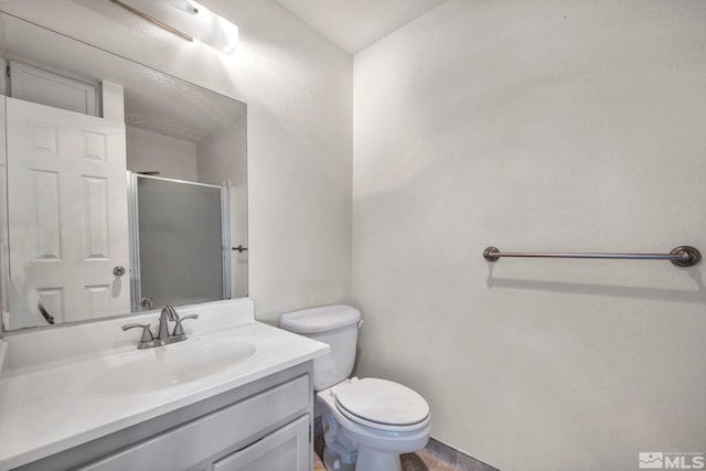 full bathroom featuring toilet, a stall shower, and vanity