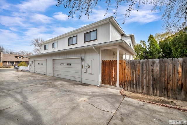 exterior space with concrete driveway and fence