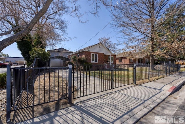 view of front of house featuring brick siding, a fenced front yard, and a gate