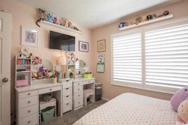 bedroom with baseboards and dark carpet