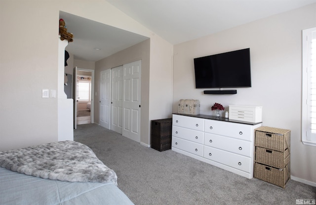 carpeted bedroom featuring a closet and baseboards