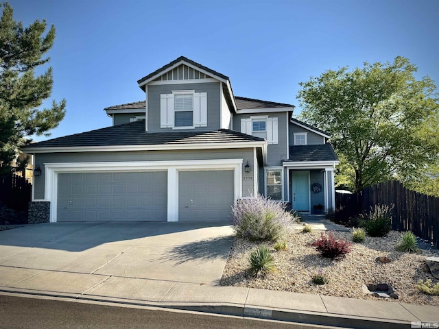 view of front of property with a garage, driveway, and fence