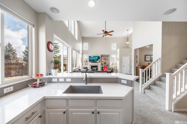 kitchen featuring a sink, a peninsula, a wealth of natural light, and a fireplace