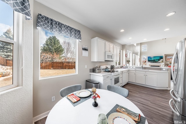 kitchen with dark wood finished floors, white cabinetry, recessed lighting, white appliances, and light countertops