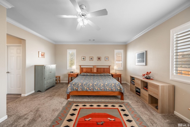 carpeted bedroom featuring visible vents, a ceiling fan, crown molding, and baseboards