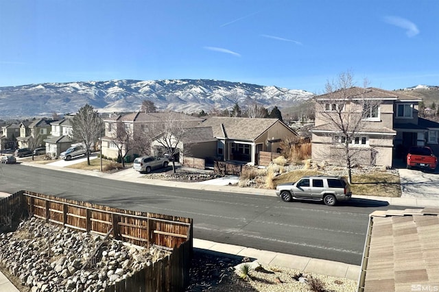 view of street with sidewalks, a mountain view, a residential view, and curbs