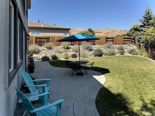 view of patio / terrace featuring fence and a mountain view