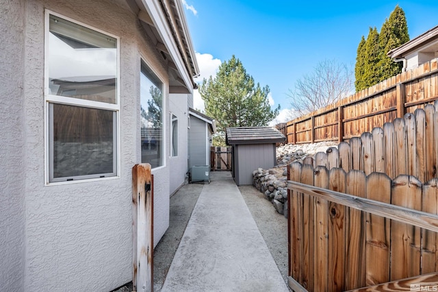 view of patio / terrace featuring a storage unit, an outbuilding, and fence