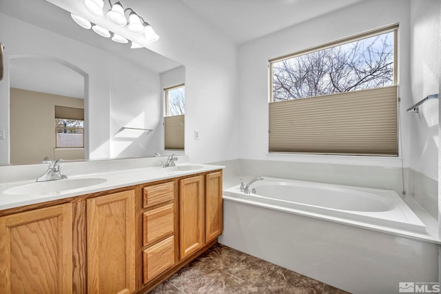 full bathroom featuring a bath, plenty of natural light, and a sink