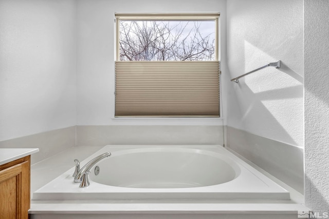 bathroom featuring vanity and a garden tub