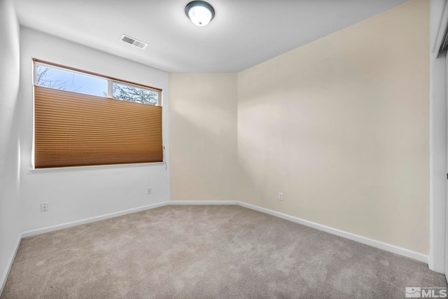 empty room with visible vents, carpet floors, and baseboards