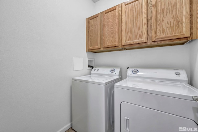 laundry area with baseboards, cabinet space, and independent washer and dryer