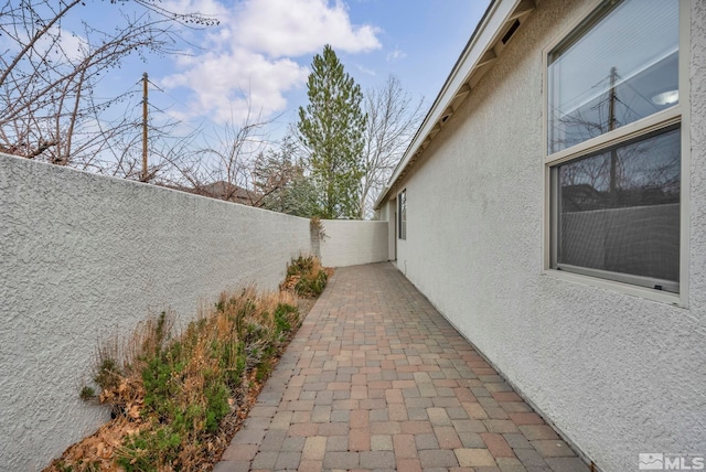 view of home's exterior with stucco siding, a patio, and a fenced backyard